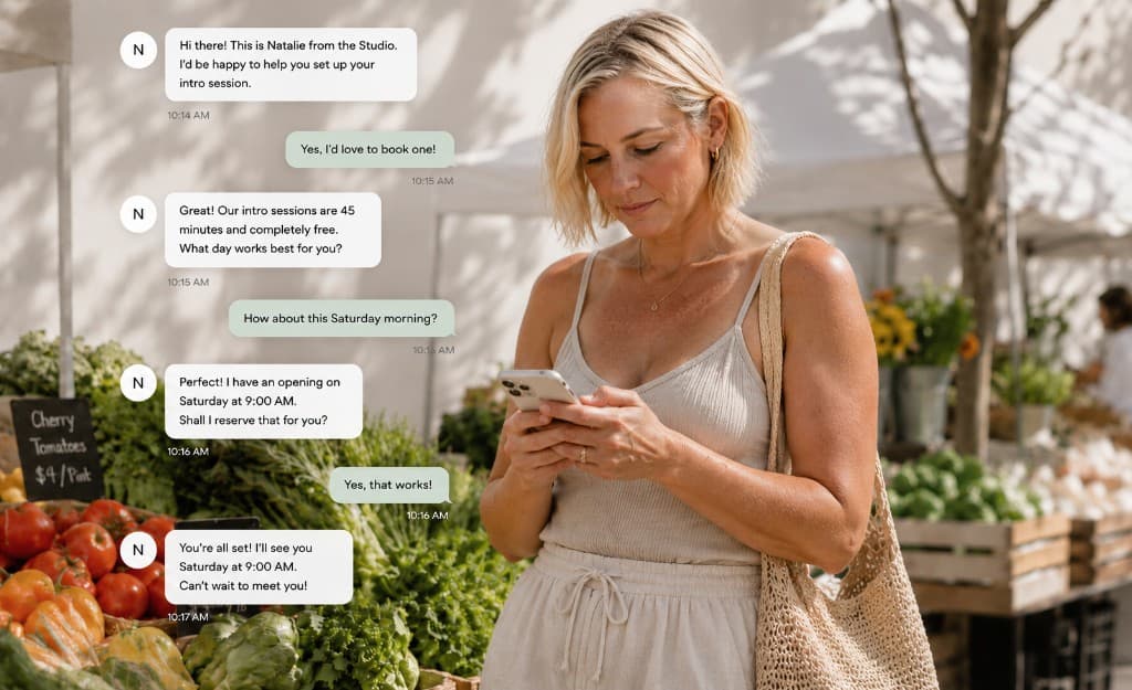 Customer at a farmer's market receiving SMS booking confirmations from a studio via Reach